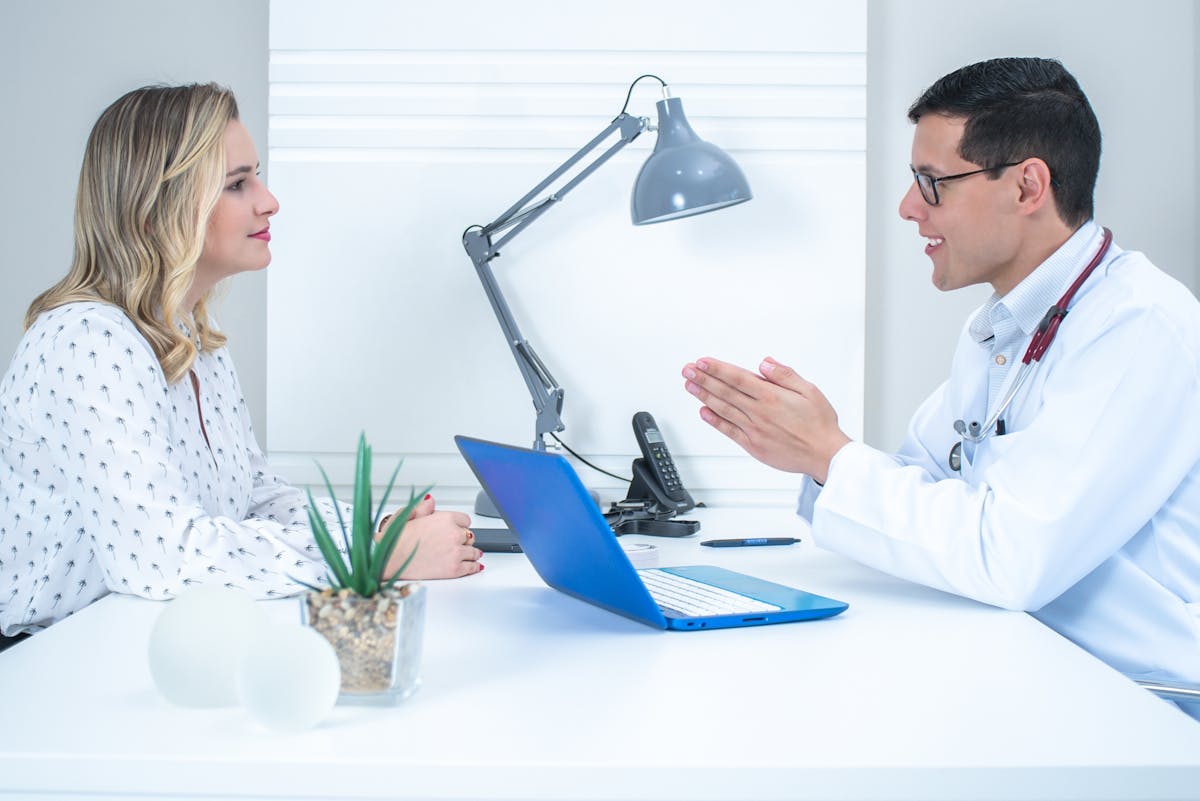 Woman at the doctors office having a consultation with a doctor.